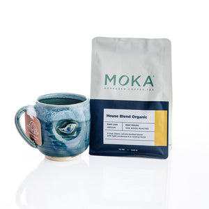 Handmade ceramic mug by Kristin Roach with a textured, swirled blue and teal glaze, featuring a small bird motif on the side and MOKA Coffee Beans Bag. Part of the MOKA x KRISTIN ROACH POTTERY exclusive, limited edition collaboration