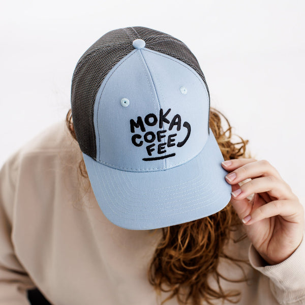 Person wearing a blue MOKA Coffee hat 